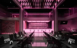 A modern bar with a long counter, stools, and pink accents, set in a restaurant atmosphere