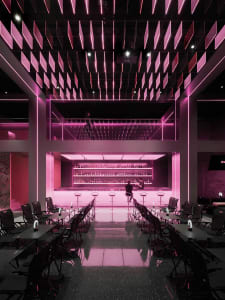 A modern bar area with pink walls, multiple chairs, and dining tables, creating a stylish and inviting atmosphere