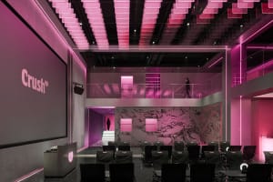 A modern lobby with a pink building, rows of chairs, and a stylish atmosphere