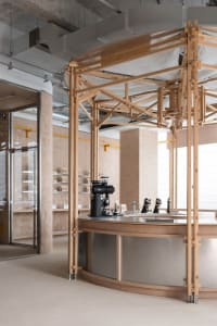Warm and inviting coffee shop interior with a counter, sink, books, and wooden accents