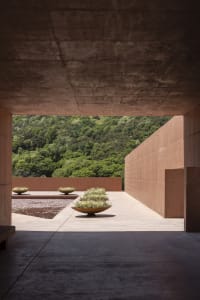 A grand building with a stone facade, featuring three vases on the ground outside, adding to its aesthetic appeal