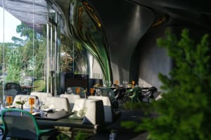 Dining area with tables, chairs, and wine glasses in an elegant restaurant interior with a focus on comfort and ambiance
