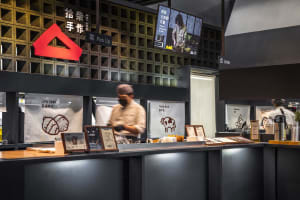 Casual Asian restaurant with a counter displaying food items, a TV on the wall, and two people in the scene