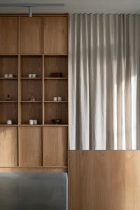 Wooden cabinets and shelves with decorative bowls on different levels, creating a warm and inviting atmosphere in the kitchen
