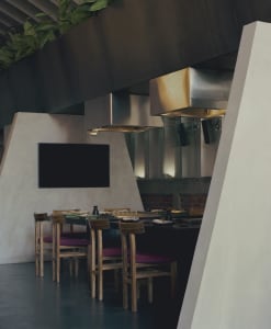 A dining area with a wooden table and chairs, set for a meal, in a restaurant with a clean and elegant atmosphere