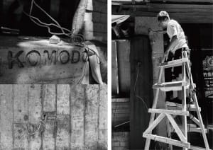 A construction site with a man working on a ladder in front of a brick wall, with two ladders and a sense of ongoing building work