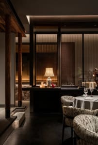 Sophisticated dining space with wooden tables and chairs, wine glasses, and a warm atmosphere