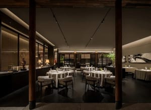 Elegant restaurant interior with multiple tables, chairs, and decorative items, creating a sophisticated atmosphere for upscale dining