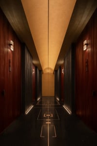 A calm and quiet hotel hallway with a carpeted floor and two doors on either side, one near the left wall and the other near the right wall