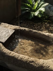 an old stone basin filled with water in a calm and serene courtyard or garden setting
