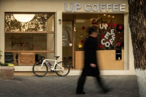 A casual coffee shop with comfortable seating, bicycles parked outside, and a welcoming atmosphere