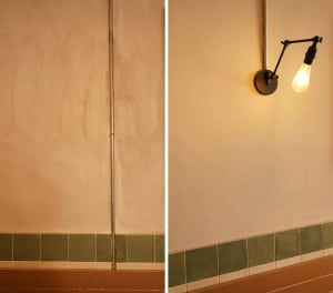 Bathroom with green tile walls and white tile walls, featuring a sink and lights