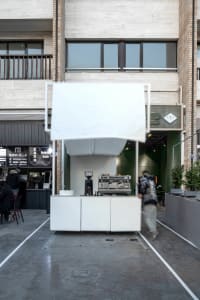 A casual cafe with multiple seating areas, tables, and chairs, creating a welcoming atmosphere for socializing and dining