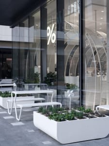A bright and inviting indoor space with a large glass window, benches, and potted plants