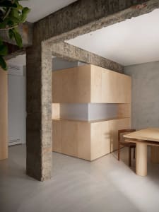 Cozy open concept living area with wooden cabinets, a dining table, and two chairs, featuring a warm and inviting atmosphere