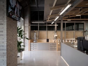 Open modern kitchen and living space with a large island, dining table, and natural light from windows