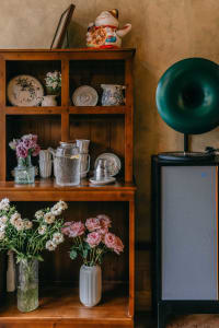 A warm and inviting living area with a wooden bookshelf featuring various decorative items, books, and vases