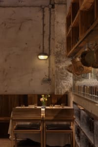 Warm and inviting dining space with wooden tables, brick walls, and multiple bottles on display