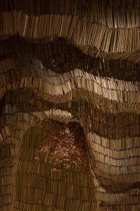A three-dimensional book structure resembling a cave or tunnel, created from stacked books, with intricate arrangement and artistic design