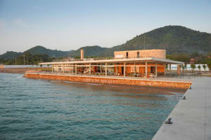 Modern waterfront building with glass walls, multiple levels, and natural light