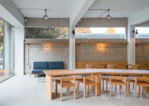 Cozy modern restaurant with wooden tables and chairs, creating a warm atmosphere for guests to enjoy meals and conversations