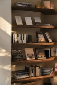 A wooden bookshelf filled with various books, arranged in an organized manner, creating a cozy and intellectual environment