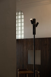 Cozy interior space with a wooden beam supporting a light fixture, illuminated by natural light from two windows