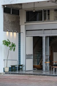 Inviting cafe interior with a staircase, chairs, and a potted plant, creating a comfortable atmosphere for guests