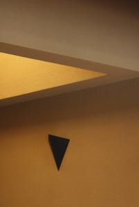 A rendered interior scene featuring a prominent triangle shape on a yellow background, with a focus on functionality and aesthetics