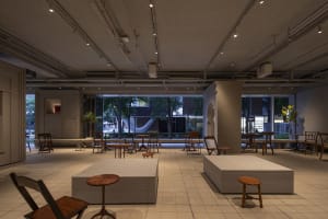 A modern living-dining space with multiple chairs, a large window, and a bright atmosphere, suitable for gatherings or social events