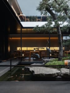 Dining room with modern design, concrete walls, and natural light from a large window