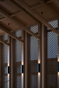A wooden building with latticework on its walls, featuring a unique blend of vertical and horizontal elements in a warm and inviting atmosphere