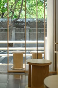 A row of wooden stools placed on a hardwood floor in a well-lit room, inviting for a meal or conversation