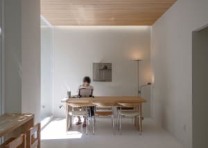 A cozy dining area with a wooden table and chairs, surrounded by white walls and a comfortable atmosphere