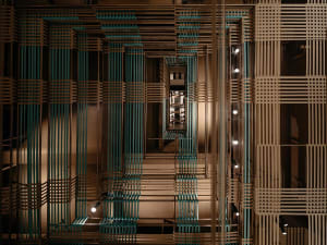 A stairwell with a spiral wooden staircase, surrounded by walls, creating a sense of depth and intricacy in the building's design