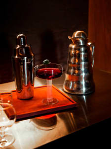 A dimly lit dining area with a metal table, wine glasses, and bowls, creating a cozy atmosphere