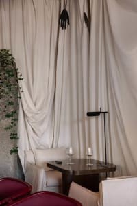 Cozy living area with a couch, dining table, chairs, white curtains, and elegant ambiance
