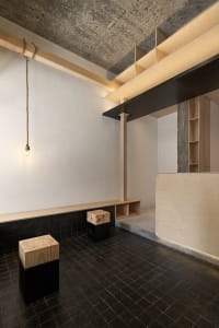 Cozy room with wooden floors and walls, featuring two benches and three stools, creating a warm atmosphere
