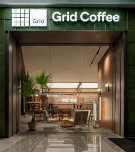 Cozy modern living area with a glass door leading to a patio, chairs around a dining table, and a kitchen area with a sink and refrigerator