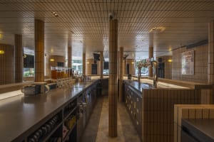 Modern bar area with brick walls, beer taps, and bottles on the countertop