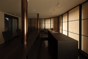 A well-lit restaurant dining area with a long wooden table and multiple chairs, creating a comfortable atmosphere for patrons