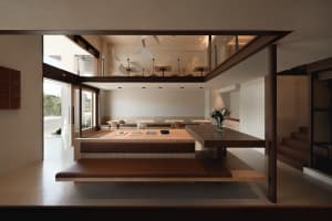 Open living area with wooden floors and walls, comfortable seating, and a potted plant, well-lit and inviting