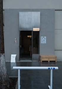 A modern Asian coffee shop with a large doorway, chairs, and a dining table, creating an inviting and comfortable atmosphere