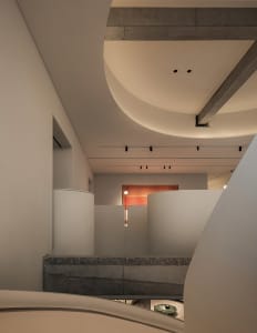 Empty modern room with a curved ceiling, a concrete wall, and a minimalist appearance