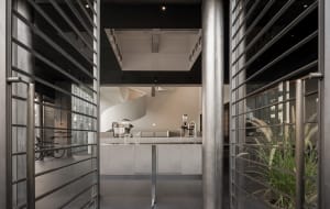 A clean and organized kitchen with two sinks, a refrigerator, microwave, and various kitchen items, set against a neutral background