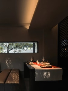 A well-set dining table in a cozy restaurant with wine glasses, bowls, and cups, surrounded by a warm atmosphere