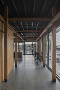 Warm and inviting restaurant interior with wooden beams, concrete flooring, and multiple tables and chairs