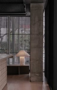 Cozy living area with a couch in front of a window, lamps, and a dining table, with natural light pouring in