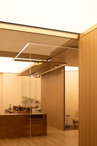 Bathroom with wooden walls and floors, featuring two sinks and a warm inviting ambiance