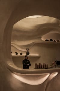 Warm and inviting restaurant interior with a bar area, vases, and comfortable atmosphere